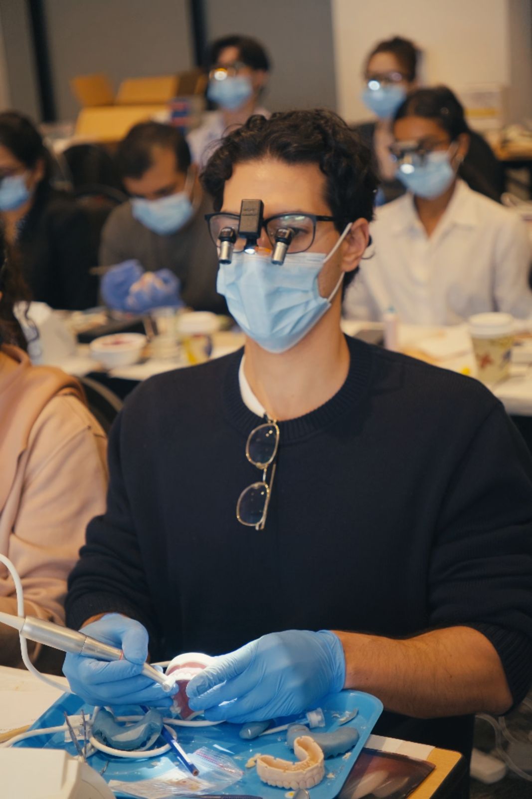 Attendee working hands-on with loupes during the masterclass